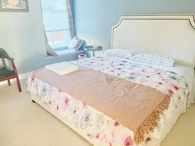 a bedroom with a bed with a floral bedspread at Derbyshire House in Coquitlam