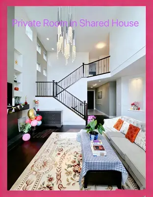 a living room with a white couch and a staircase at Derbyshire House in Coquitlam