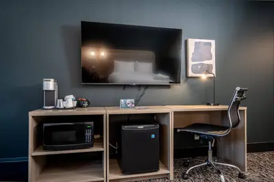 a desk with a computer and a chair in a room at Northwinds Hotel Revelstoke in Revelstoke