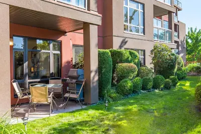 a house with a garden with a hedge at Resort Style Living with Private Lawn and Patio in Kelowna