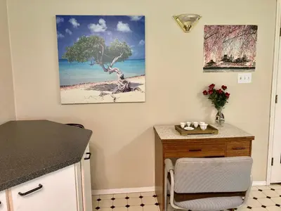 a kitchen with a table and a desk with a tree on the wall at Red Robe B&B in Nanaimo