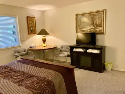 a bedroom with a bed and a tv and a table at Red Robe B&B in Nanaimo