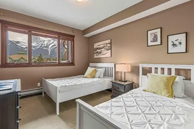 a bedroom with two beds and a window at Best Views of Canmore - 2Bed 2Bath in Canmore