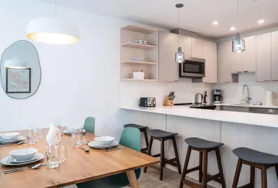 a kitchen and dining room with a wooden table and chairs at Serenity Now by Revelstoke Vacations in Revelstoke