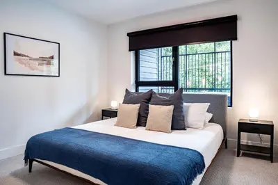 a bedroom with a large bed with a blue blanket at Serenity Now by Revelstoke Vacations in Revelstoke