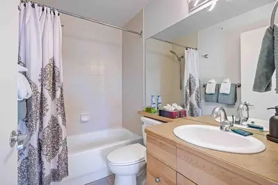 a bathroom with a sink and a toilet and a tub at Lux 2BR 5BD Suite Mountain view! in Canmore