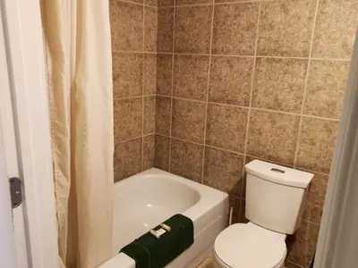 a bathroom with a toilet and a bath tub at Caravan Motel in Fort Saint John