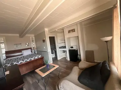 a bedroom with a bed and a living room at Caravan Motel in Fort Saint John
