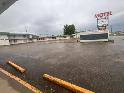 a motel parking lot with a truck parked in it at Caravan Motel in Fort Saint John