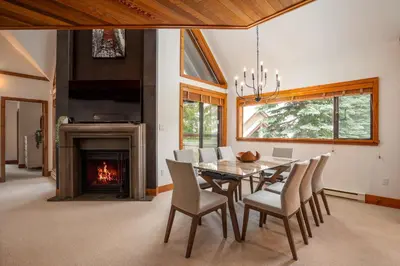 a dining room with a table and chairs and a fireplace at 3BR in Snowberry, King Bed, Wood Burning Fireplace, Large Kitchen, Near Gondola in Whistler