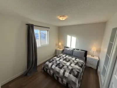 a small bedroom with a bed and a window at Spacious & Private Retreat near West Edmonton Mall in Edmonton