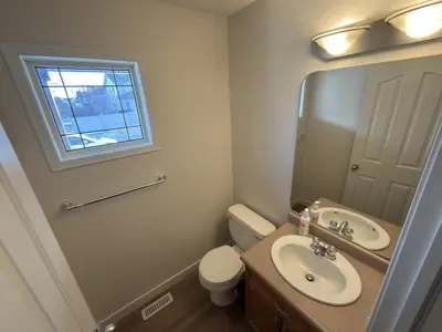 a bathroom with a sink and a toilet and a mirror at Spacious & Private Retreat near West Edmonton Mall in Edmonton