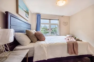 a bedroom with a large bed and a window at Lux 2BR/3BD Suite/Mountain View! in Canmore