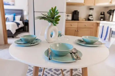 a white table with three bowls and plates on it at Lux 2BR/3BD Suite/Mountain View! in Canmore