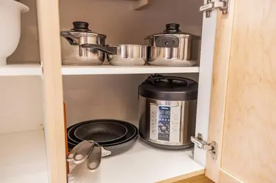 a pantry with two pots and pans on a shelf at Lux 2BR/3BD Suite/Mountain View! in Canmore