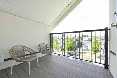 a balcony with two chairs and a large window at Four bedrooms New Lovely Duplex -1626 in Vancouver
