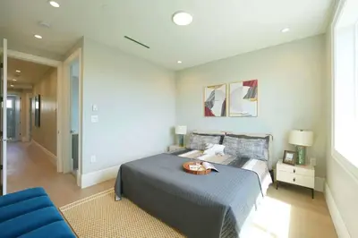 a bedroom with a bed and a blue couch at Four bedrooms New Lovely Duplex House-1628 in Vancouver