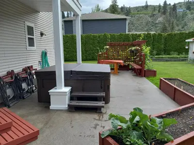 a backyard patio with a grill and a bench at Grumpy's Suite by the Lake in Summerland