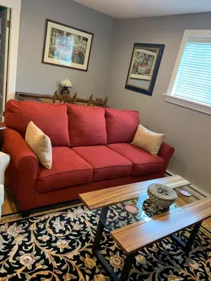 a red couch in a living room with a coffee table at Sweetest Suite Downtown in Salmon Arm
