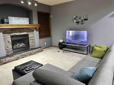 a living room with a couch and a flat screen tv at Spacious, 2-story Family-Friendly home in Calgary
