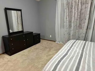 a bedroom with a bed and a dresser with a mirror at Spacious, 2-story Family-Friendly home in Calgary