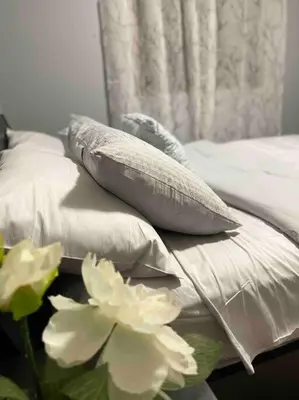 a bed with white pillows and a flower on it at Spacious, 2-story Family-Friendly home in Calgary