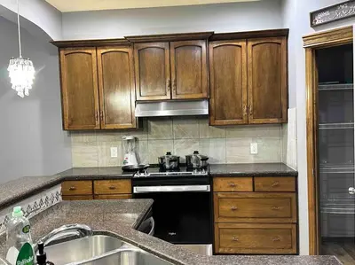 a kitchen with wooden cabinets and a stove top oven at Spacious, 2-story Family-Friendly home in Calgary