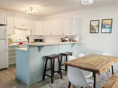a kitchen with white cabinets and a wooden table at Bright 3 bed 3 bath House in Radium Hot Springs in Radium Hot Springs