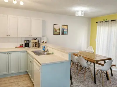 a kitchen with a sink and a table with chairs at Bright 3 bed 3 bath House in Radium Hot Springs in Radium Hot Springs