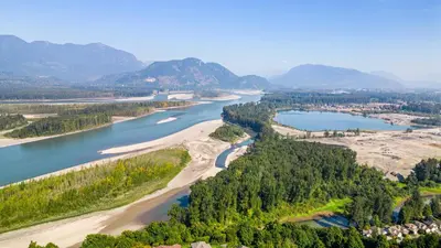 an aerial view of a river with mountains in the background at Grand English Style Home in Chilliwack
