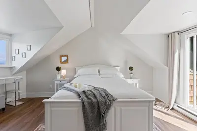 a white bedroom with a white bed and a window at Grand English Style Home in Chilliwack