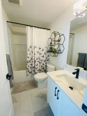 a bathroom with a toilet and a sink and a shower at The Royal Bay Escape: Cozy 2 bedrooms garden suite in Colwood