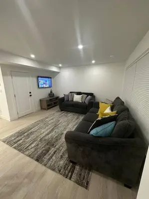 a living room with a couch and a flat screen tv at The Royal Bay Escape: Cozy 2 bedrooms garden suite in Colwood