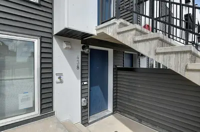 a stairway with a blue door on a house at Cozy New Suite in Seton, South Calgary in Calgary