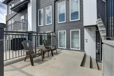 two chairs sitting on a balcony of a house at Cozy New Suite in Seton, South Calgary in Calgary