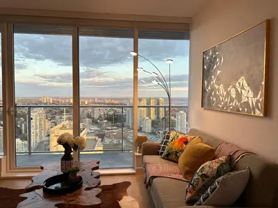 a living room with a couch and a large window at Pacific Sweet Place @Metro in Burnaby