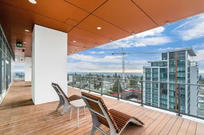 a balcony with chairs and a view of a building at Pacific Sweet Place @Metro in Burnaby