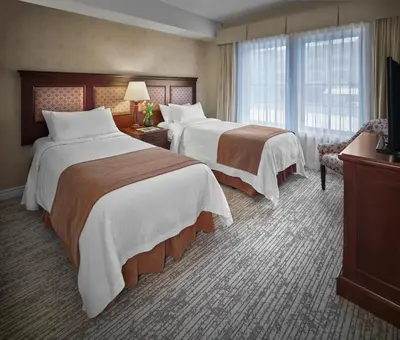a hotel room with two beds and a television at Residences at the Sun Peaks Grand in Sun Peaks
