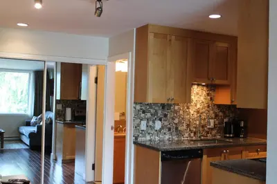 a kitchen with wooden cabinets and black counter tops at The Après Suite in Whistler