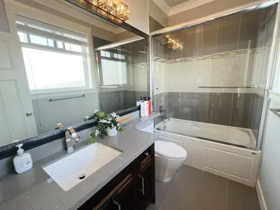 a bathroom with a sink and a tub and a toilet at Jennifer's House in Vancouver
