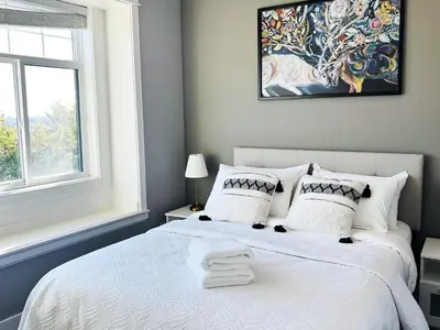 a bedroom with a white bed and a window at Jennifer's House in Vancouver