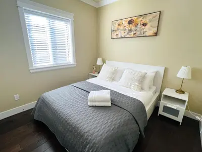 a bedroom with a bed and a window at Jennifer's House in Vancouver