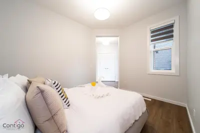a white bedroom with a white bed and a window at Orchards Retreat, AC, Family Friendly, Sleeps 10, NearAirprt in Nisku