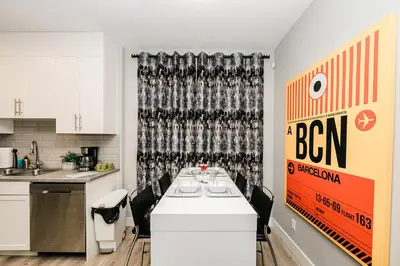 a kitchen with a table with a sign on the wall at Modern suite near Airport Hospital Henday Town Ctr in Nisku