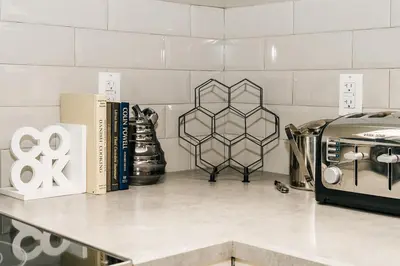 a counter with books and a toaster on a shelf at Modern suite near Airport Hospital Henday Town Ctr in Nisku