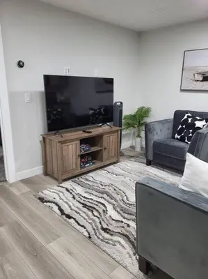 a living room with a flat screen tv and a couch at Serene Haven - 1 bedroom apartment. in Calgary