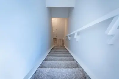 an empty hallway with stairs in an empty room at Stylish Getaway 2BD Basement by YMCA and South Health Campus Hospital in Calgary