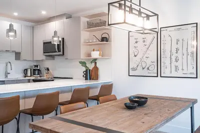 a kitchen with a wooden table and some chairs at Glades and Greens by Revelstoke Vacations in Revelstoke