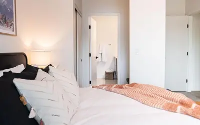 a bedroom with a large white bed with pillows at The Monashee House by Revelstoke Vacations in Revelstoke