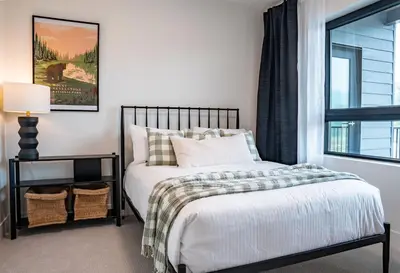 a bedroom with a bed and a window at The Selkirk House by Revelstoke Vacations in Revelstoke